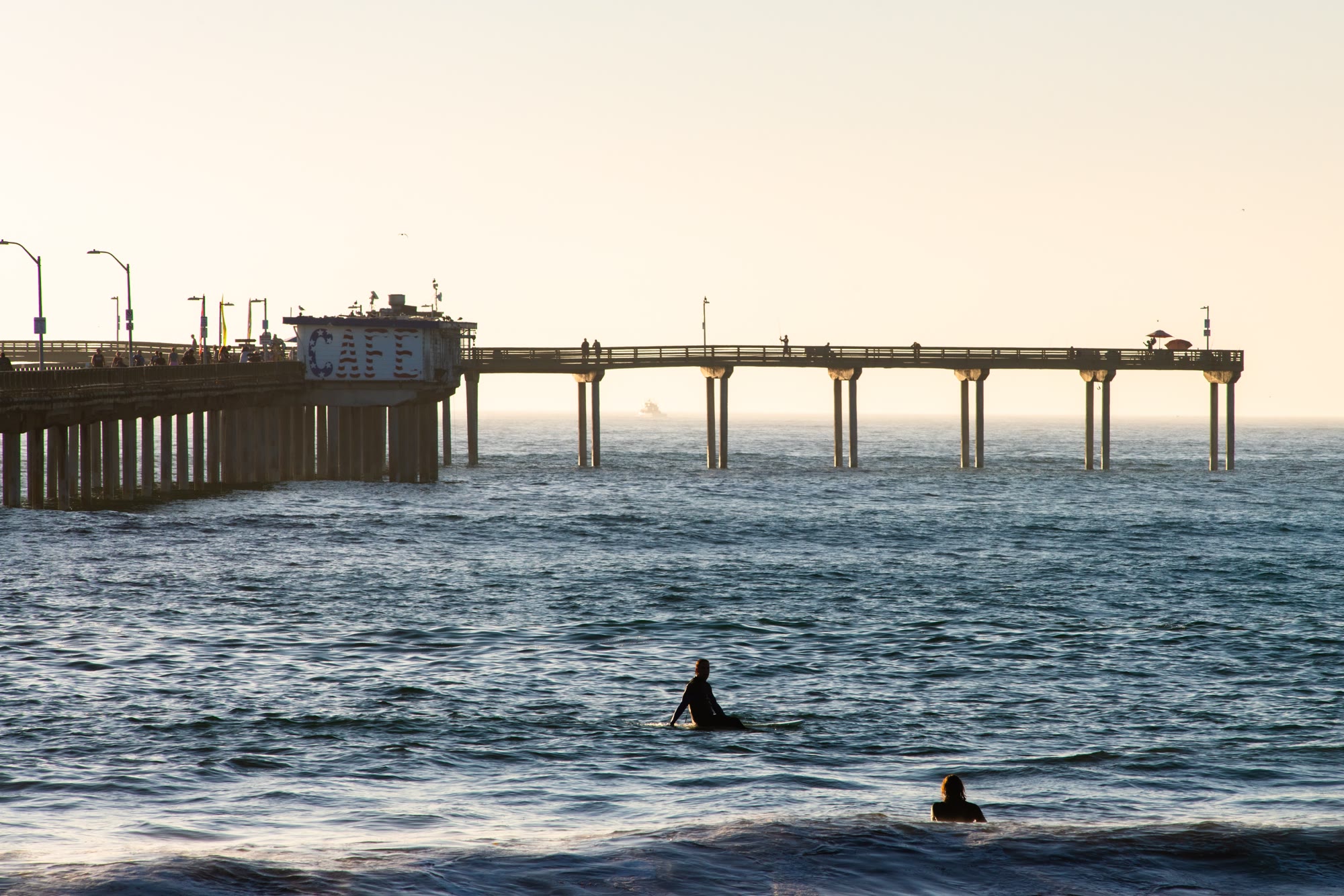 Surfers Surfing at The Ocean Beach Pier during a beautiful