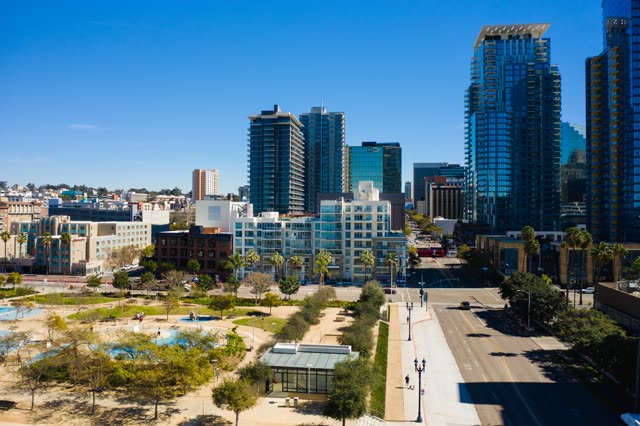 Low aerial view of the downtown streets, the skyline and palm trees at Waterfront.