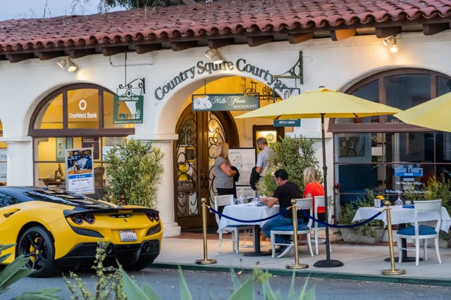 The downtown streets, the buildings and traffic at Covenant, with people eating outside.