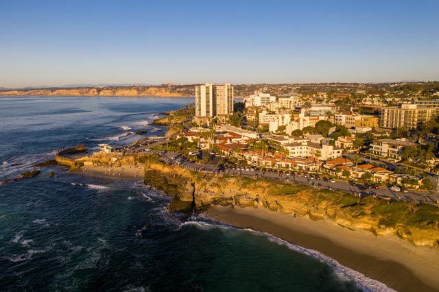 Aerial view of the beach, the surf and the ocean at La Jolla Cove, with people walking.