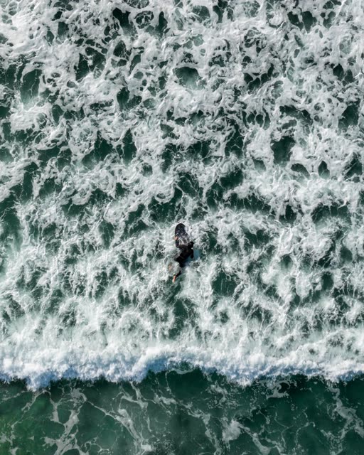 Surfer duck diving under a wave at Cardiff State Beach | Drone Photo