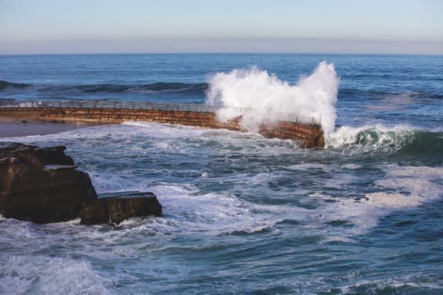 Elevated view of the cliffs, the surf and the ocean at La Jolla Cove.