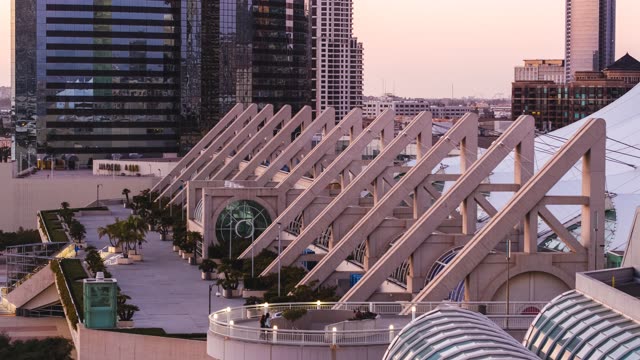 Low aerial view of the downtown streets, the skyline and palm trees at Embarcadero, with people walking.