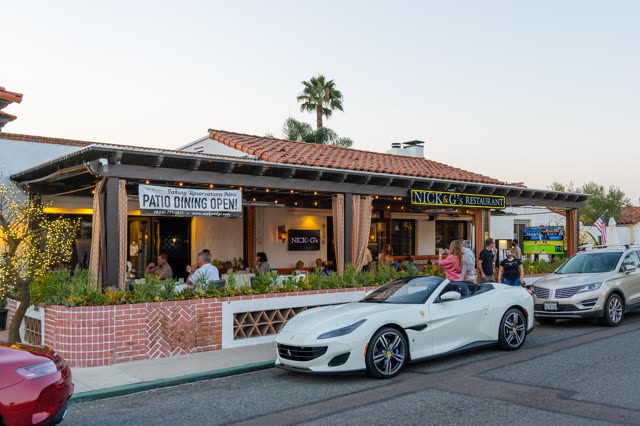The downtown streets, palm trees and the buildings at Covenant, with people eating outside.