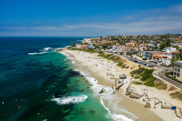 Aerial view of the beach, the surf and the ocean at Windansea, with swimmers in the water.