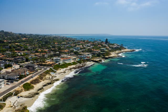 Aerial view of the cliffs, the surf and palm trees at Windansea.