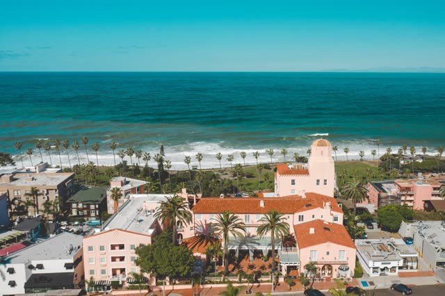 Aerial view of the beach, the surf and palm trees at La Jolla Cove.