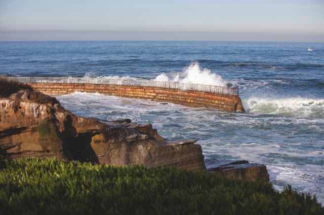 Elevated view of the cliffs, the surf and the ocean at La Jolla Cove.