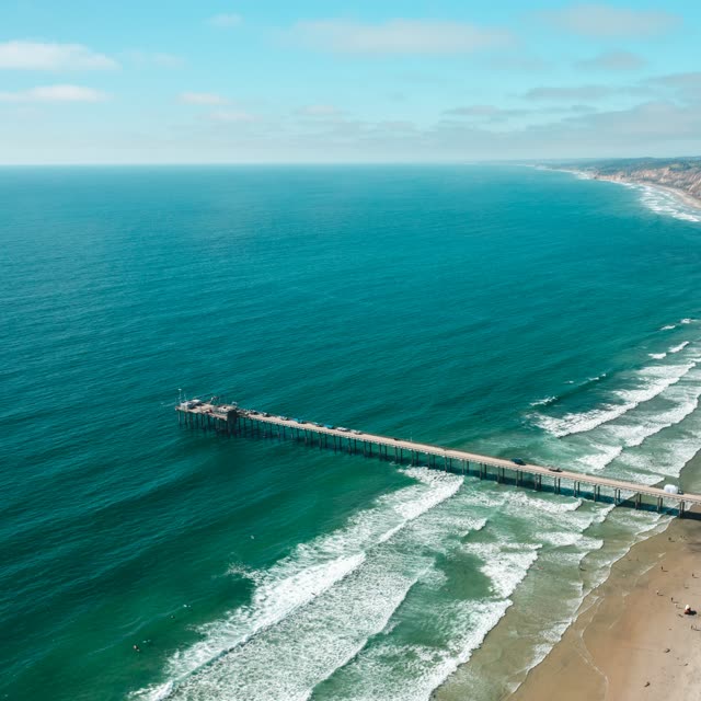 Aerial view of the beach, the surf and the pier at La Jolla Farms.