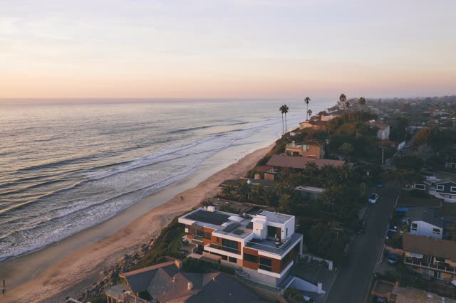 Aerial view of the beach, the surf and palm trees at Moonlight Beach.