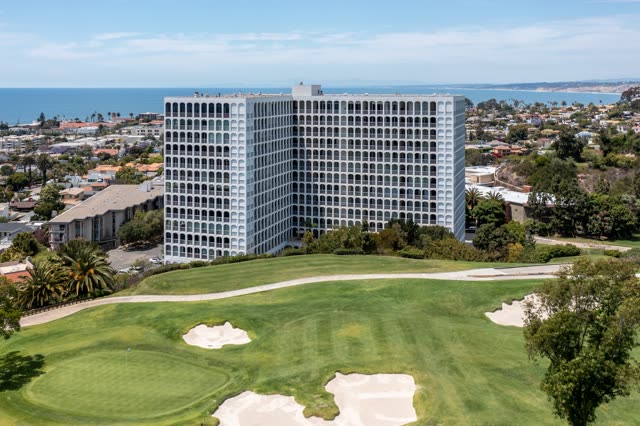 Aerial view of a residential street, palm trees and the ocean at La Jolla Country Club.