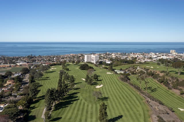 Aerial view of the country inland, the ocean and homes at La Jolla Country Club.