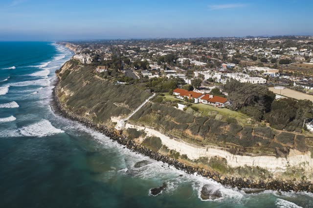 Aerial view of the cliffs, the surf and palm trees at Swamis.