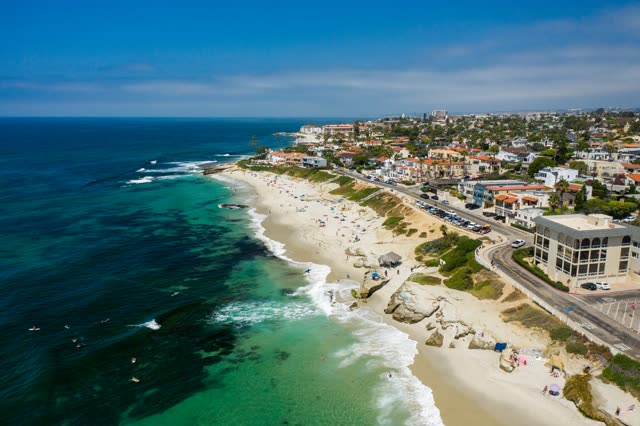 Aerial view of the beach, the surf and the ocean at Windansea, with swimmers in the water.