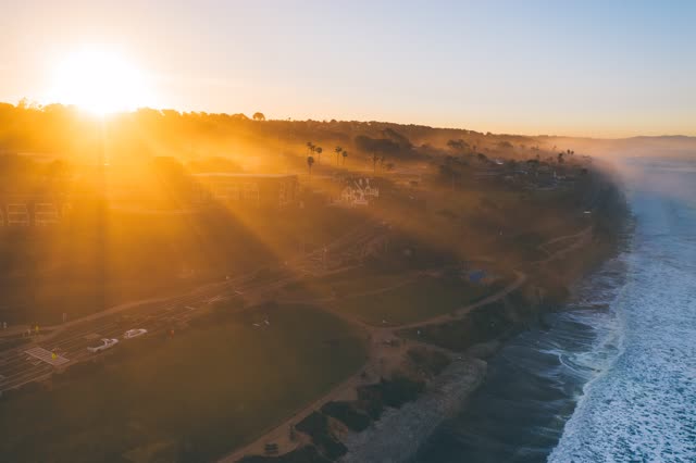 Aerial view of the cliffs, the surf and palm trees in Del Mar.