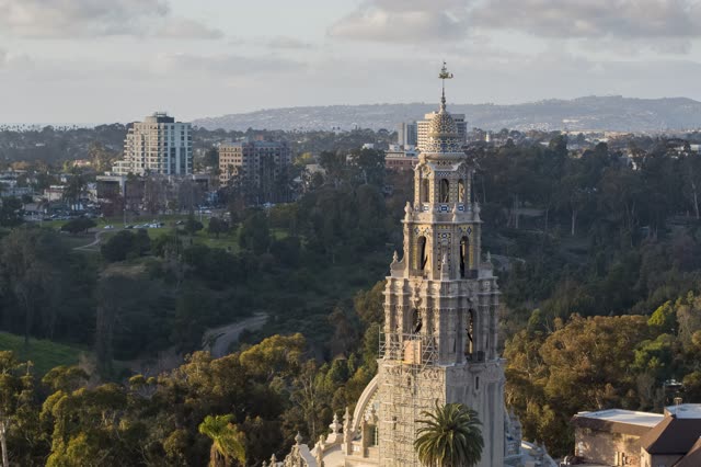 Aerial view of a park, the skyline and the buildings in Balboa Park, with a work crew on site.
