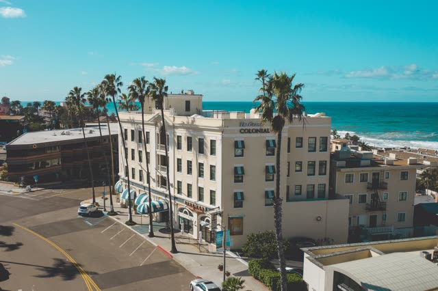 Low aerial view of the downtown streets, palm trees and the ocean at La Jolla Cove.