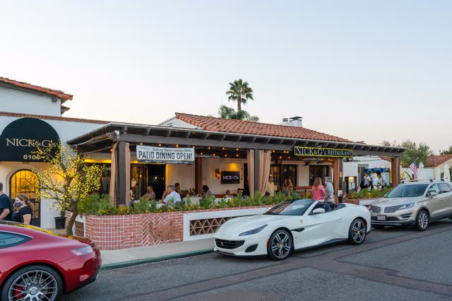 The downtown streets, palm trees and the buildings at Covenant, with people eating outside.