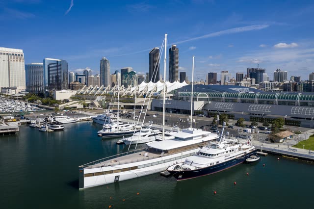 Low aerial view of the harbor, the skyline and boats in Downtown San Diego, with boats out.