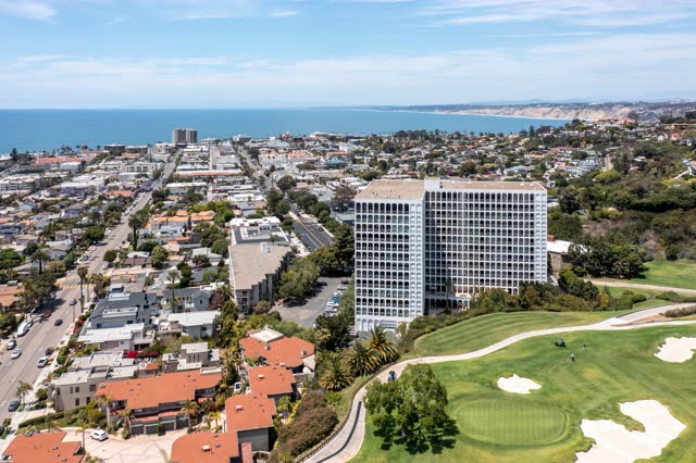 Aerial view of a residential street, palm trees and the ocean at La Jolla Country Club.