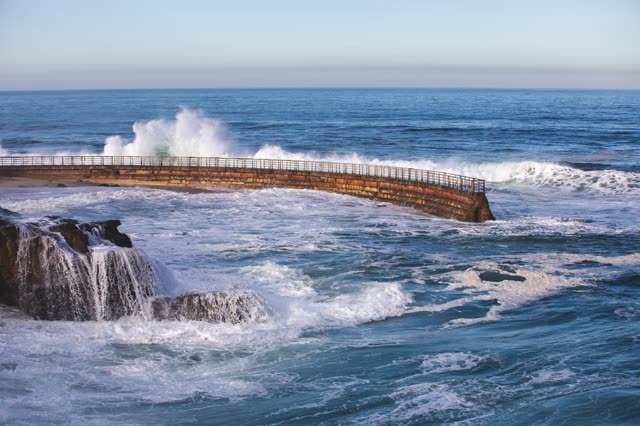Elevated view of the cliffs, the surf and the ocean at La Jolla Cove.