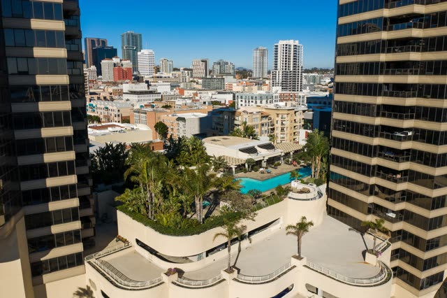 Low aerial view of the downtown streets, the skyline and palm trees at San Diego Marina.