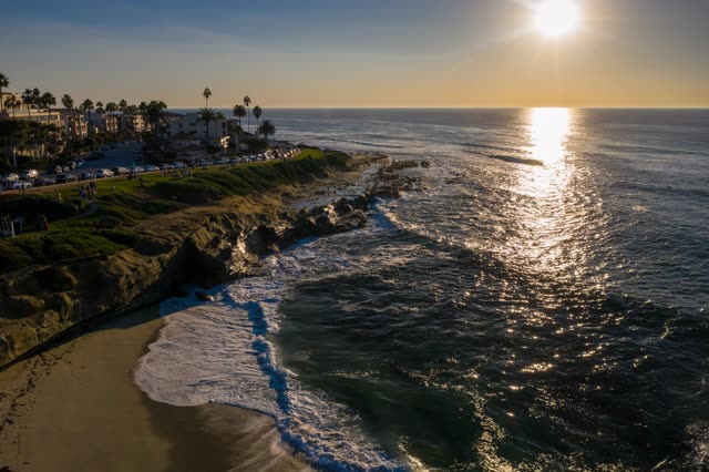 Aerial view of the cliffs, the surf and palm trees at La Jolla Cove.