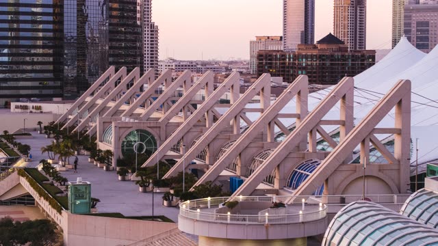 Low aerial view of the downtown streets, the skyline and palm trees at Embarcadero, with people walking.