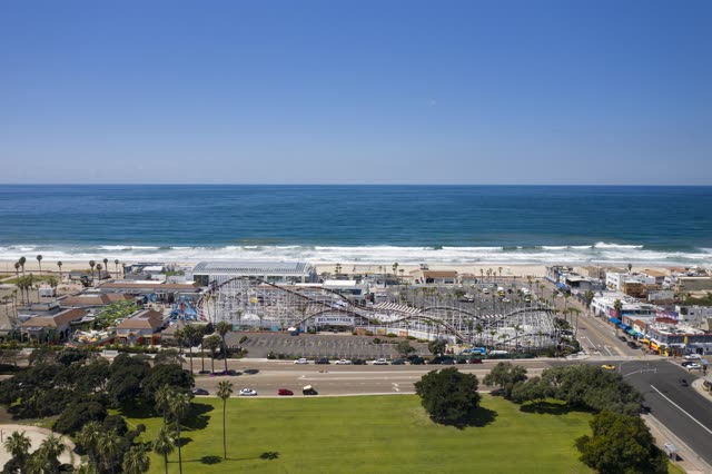 Aerial view of the beach, the surf and palm trees at Belmont Park.