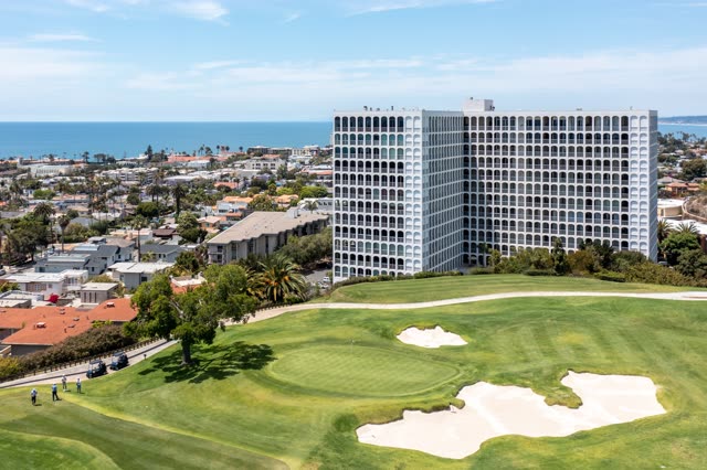 Aerial view of a residential street, palm trees and the ocean at La Jolla Country Club.