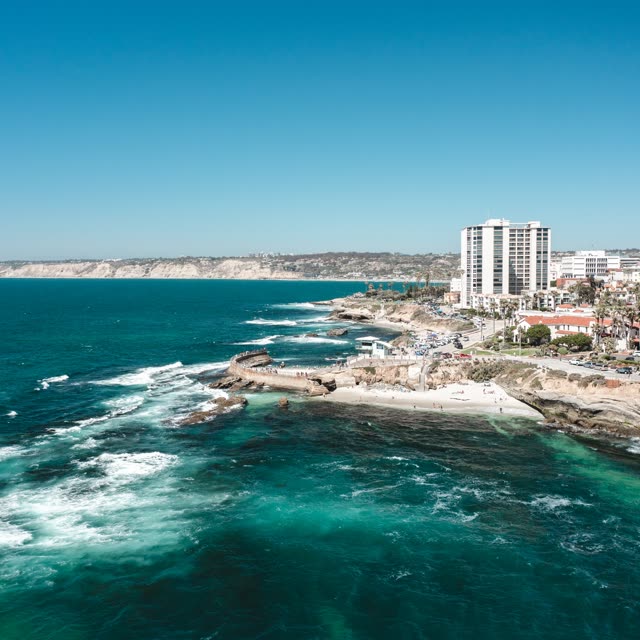 Aerial view of the cliffs, the surf and the ocean at La Jolla Cove.