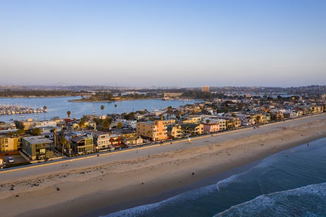 Aerial view of the beach, boats and the ocean in Mission Bay, with people walking.