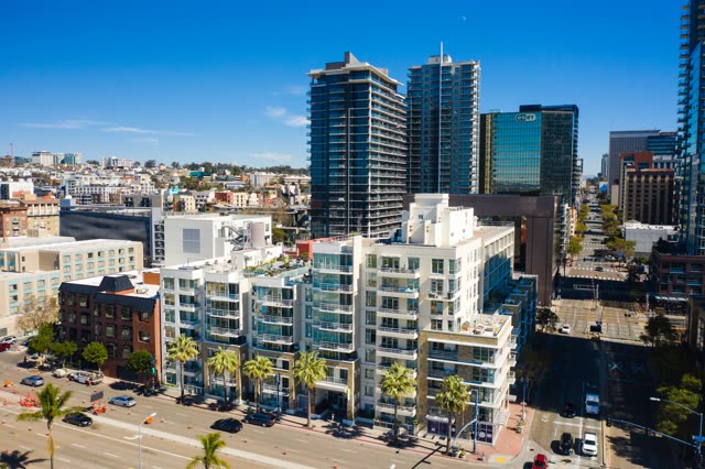 Low aerial view of the downtown streets, the skyline and palm trees at Waterfront.