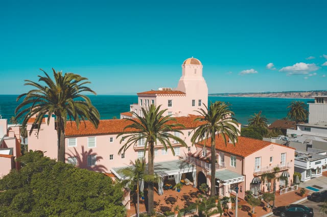 Low aerial view of the downtown streets, palm trees and the ocean at La Jolla Cove.