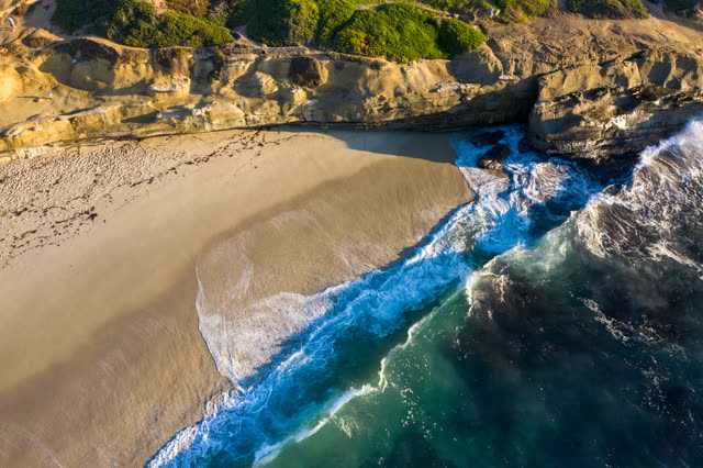 Aerial view of the cliffs, the surf and the ocean at La Jolla Cove.