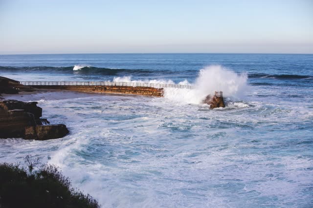 Elevated view of the cliffs, the surf and the ocean at La Jolla Cove.