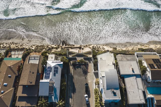 Aerial view of a residential street, the surf and the ocean in Encinitas.