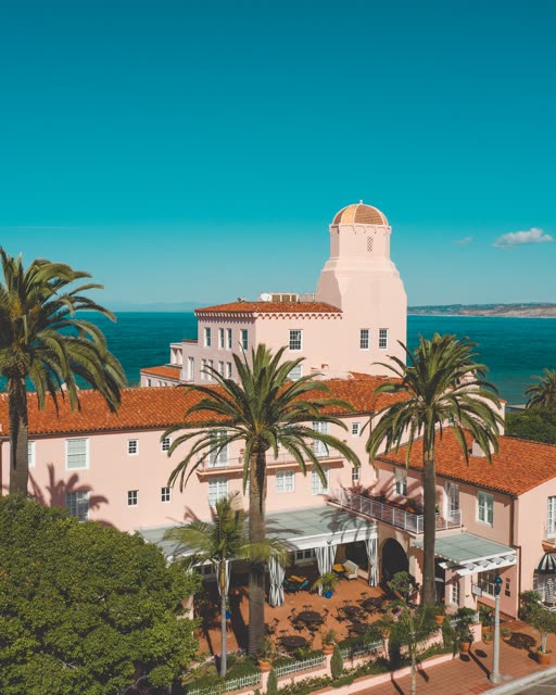 Low aerial view of the downtown streets, palm trees and the ocean at La Jolla Cove.