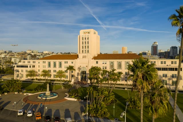 Low aerial view of the downtown streets, the skyline and palm trees at Waterfront.