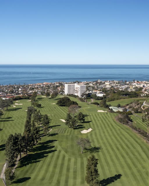 Aerial view of the country inland, the ocean and homes at La Jolla Country Club.