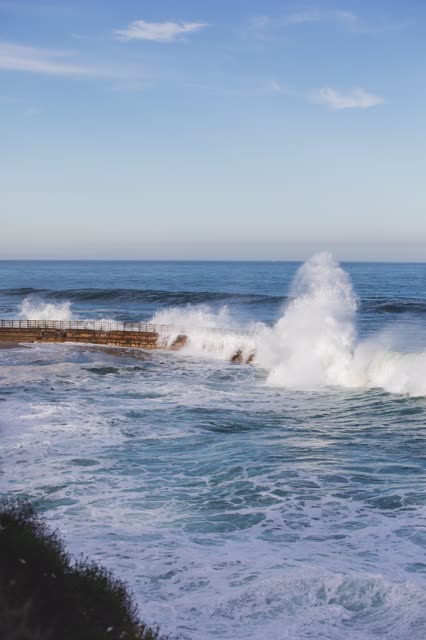 Elevated view of the cliffs, the surf and the ocean at La Jolla Cove.