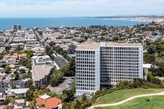Aerial view of a residential street, palm trees and the ocean at La Jolla Country Club.