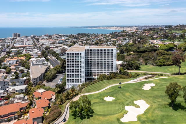 Aerial view of a residential street, palm trees and the ocean at La Jolla Country Club.
