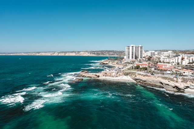 Aerial view of the cliffs, the surf and the ocean at La Jolla Cove.