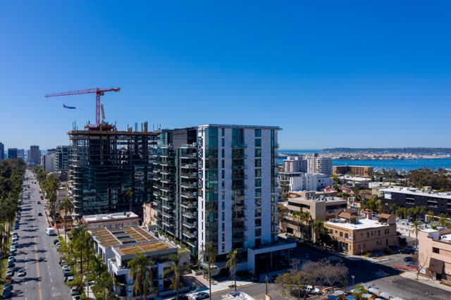 Aerial view of the downtown streets, the skyline and palm trees at Bankers Hill, with a work crew on site.