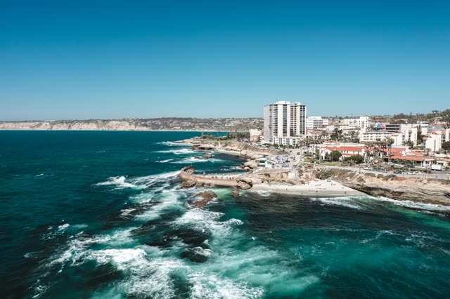 Aerial view of the cliffs, the surf and the ocean at La Jolla Cove.