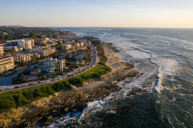 Aerial view of the cliffs, the surf and palm trees at La Jolla Cove.