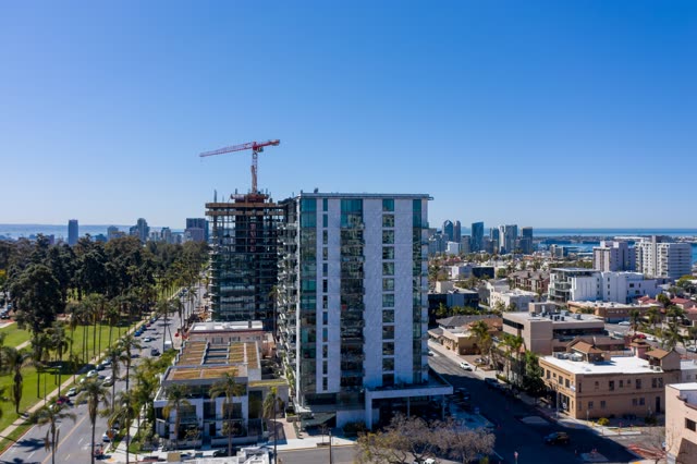 Aerial view of the downtown streets, the skyline and palm trees at Bankers Hill, with a work crew on site.