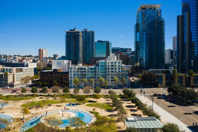 Aerial view of the downtown streets, the skyline and palm trees at Waterfront, with people walking.