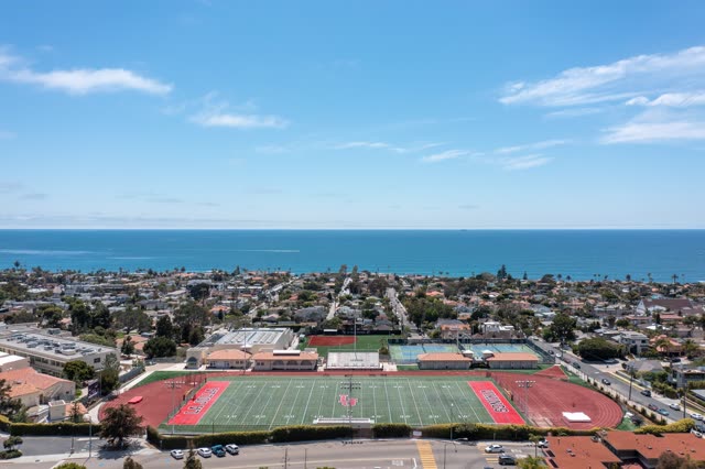 Aerial view of a residential street, palm trees and the ocean at La Jolla Country Club.